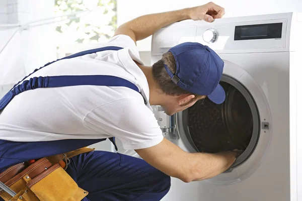 depositphotos_135386498-stock-photo-plumber-repairing-washing-machine
